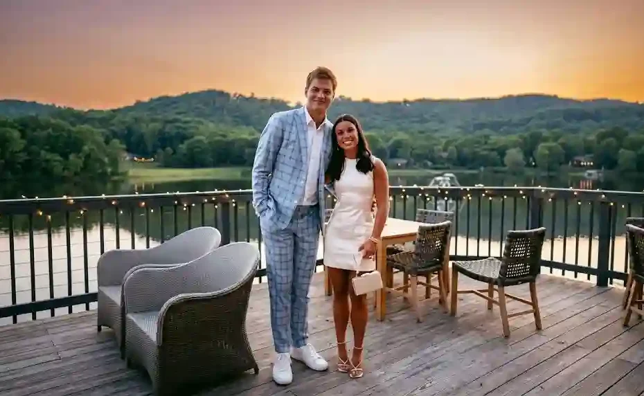NFL quarterback Drake Maye posing outdoors with his wife Ann Michael Maye on a scenic wooden patio overlooking a lake.